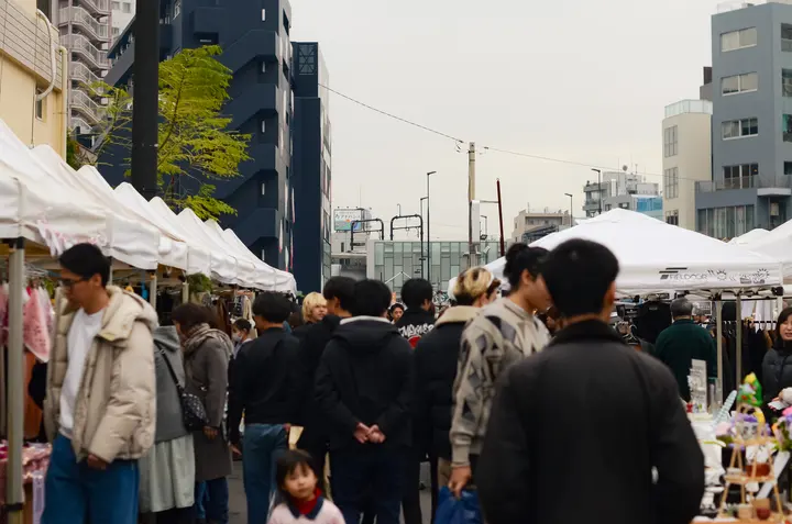 白いテントが両側に並ぶ通りに集まった、大勢の来場者